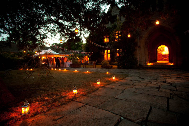 Sheldon Manor wedding venue in Chippenham lit up at night by tea light lanterns