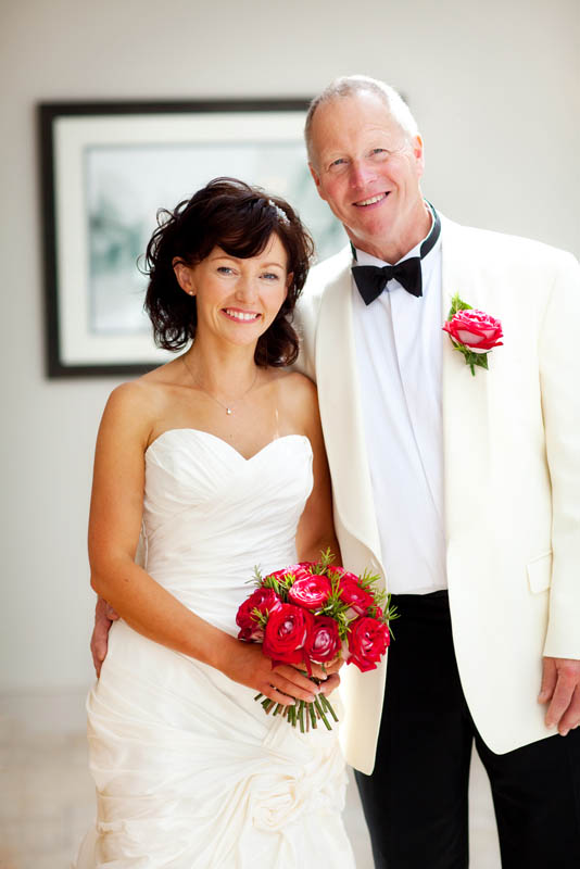 A bride and groom both in white stand close together for a photo at The Mount Somerset wedding venue
