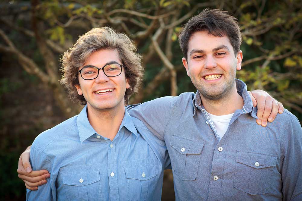 two young men smile to camera at a family occasion
