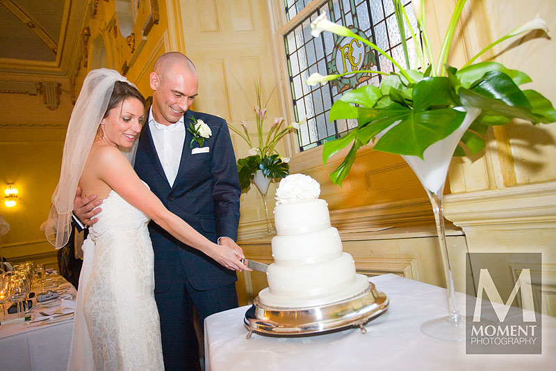 A bride and groom cutting the wedding cake in the Royal Clarence Hotel in Exeter