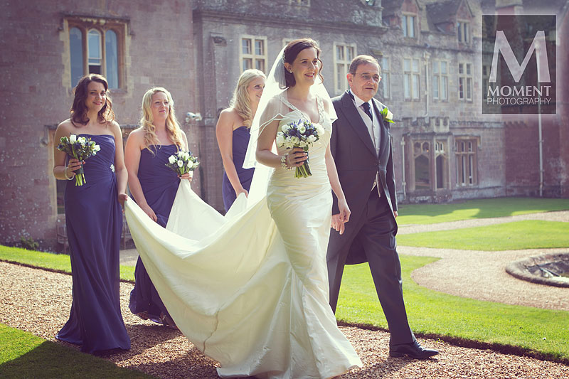 A bride at St Audries Park walking to the Orangery with her father and bridesmaids