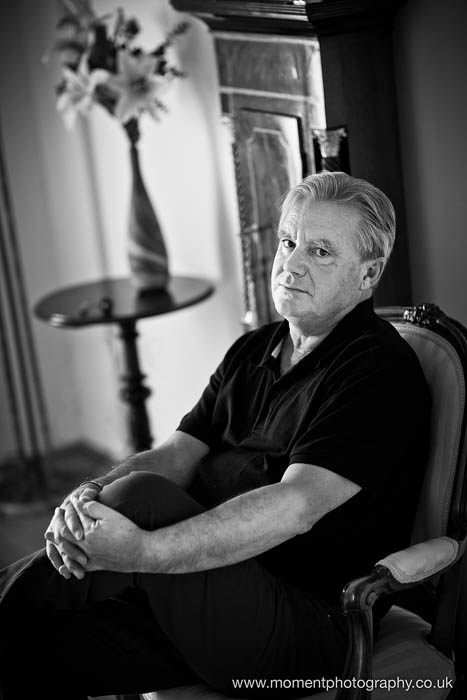 Black and white Portrait of author Neil Grimmett sitting holding his knee
