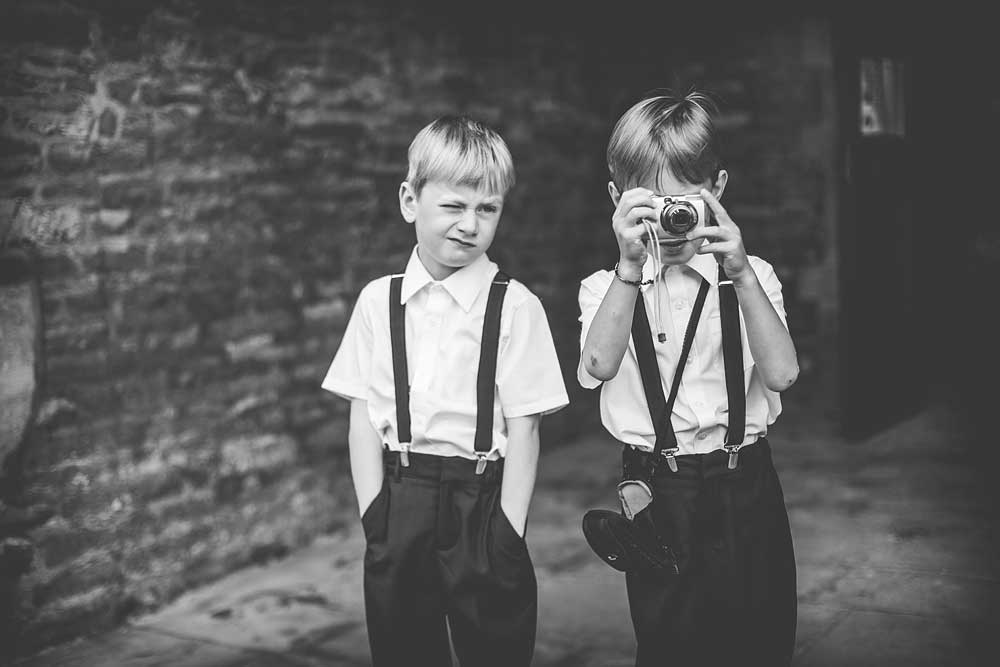 Black-and-white photo of two young boys and one of them is holding a camera
