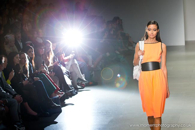 London Fashion Weekend catwalk model with bright flash in the background