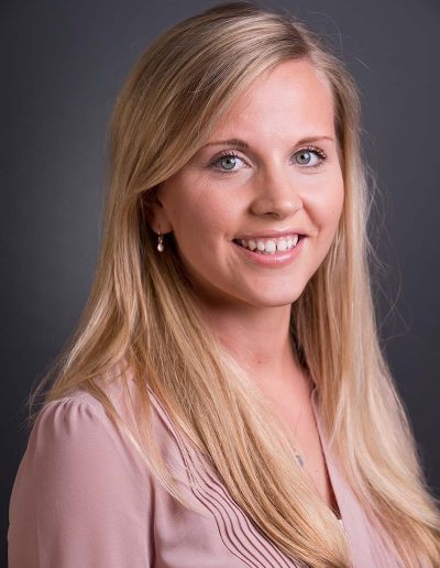 Staff business headshot of a pretty young blonde woman with a peach coloured blouse