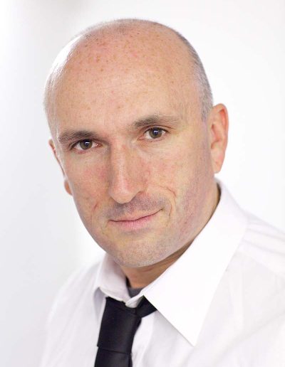 Male headshot of a man in a white shirt against a white background