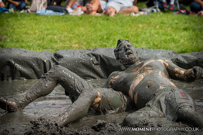 Muddy men struggle to see through the mud on their face during the popular mud wrestling at The Lowland Games 2016