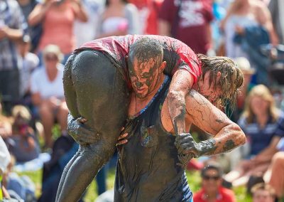 Young man and his girlfriend mud wrestling in front of an audience in Somerset