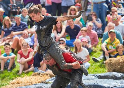 Young man and his girlfriend mud wrestling in front of an audience in Somerset