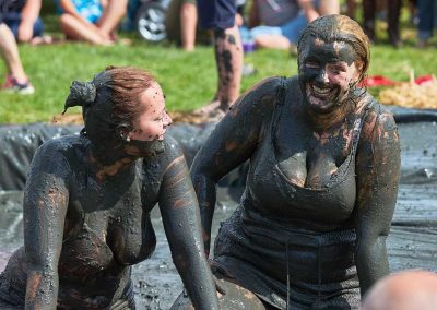 Two young women covered in mud, mud wrestling in Thorney, Somerset
