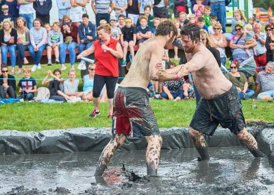 Two young men covered in mud, mud wrestling in Thorney, Somerset