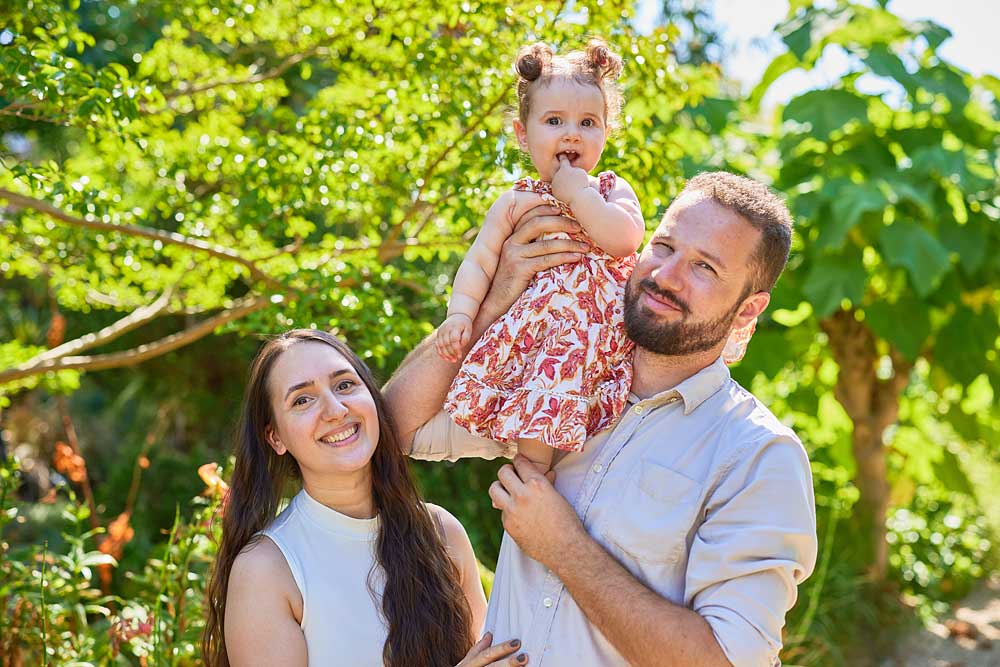 Young couple holding up baby