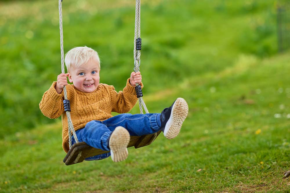 Little boy on swing at Sheafhayne Manor in Honiton